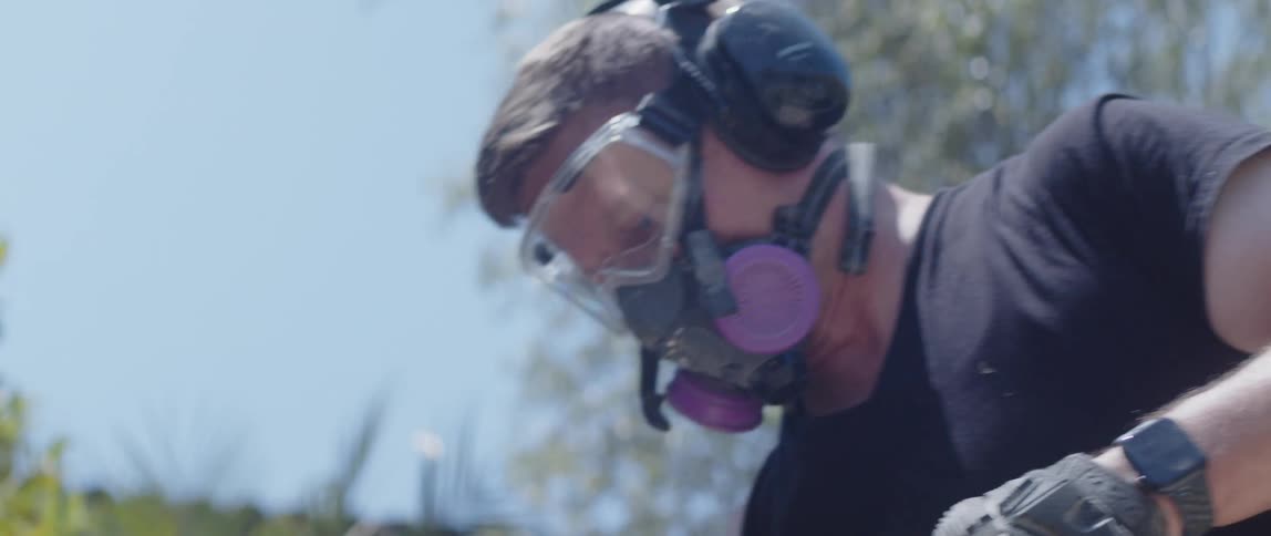 Man with glasses headphones and protective mask working in an outdoor environment
