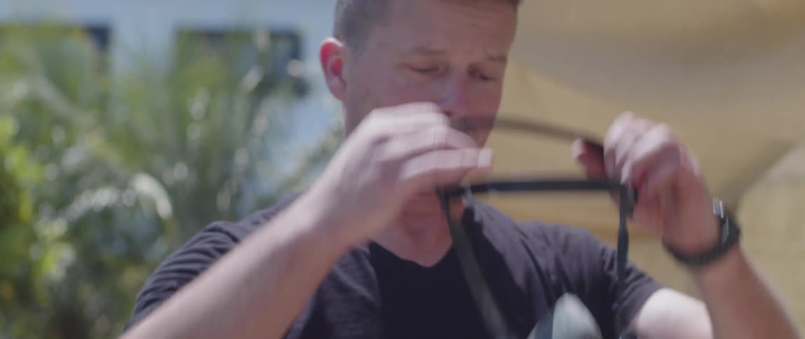 Man in his backyard putting on a protective mask
