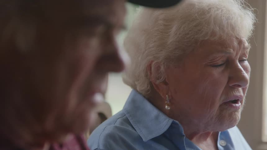 Elderly couple sitting side by side talking