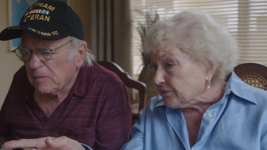 Elderly couple sitting at a table talking
