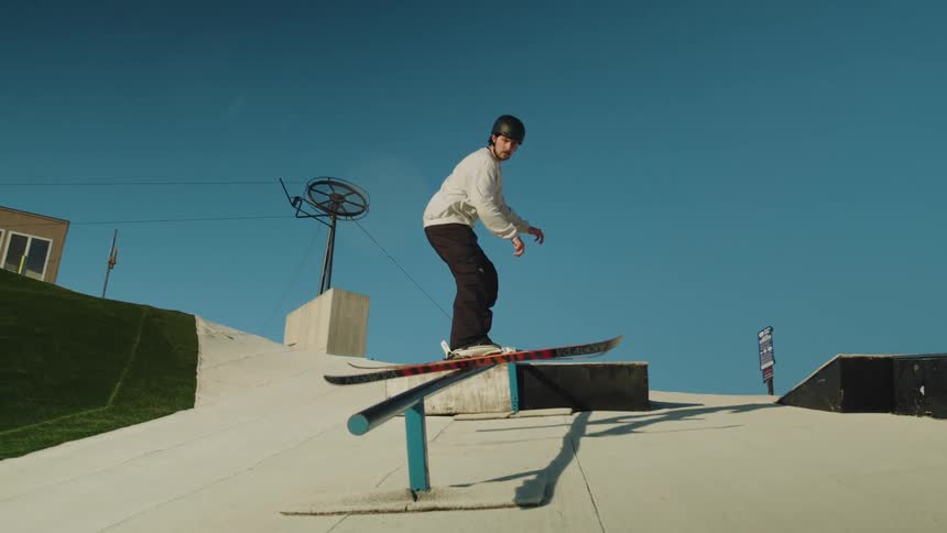 A young man slides down a railing while skiing