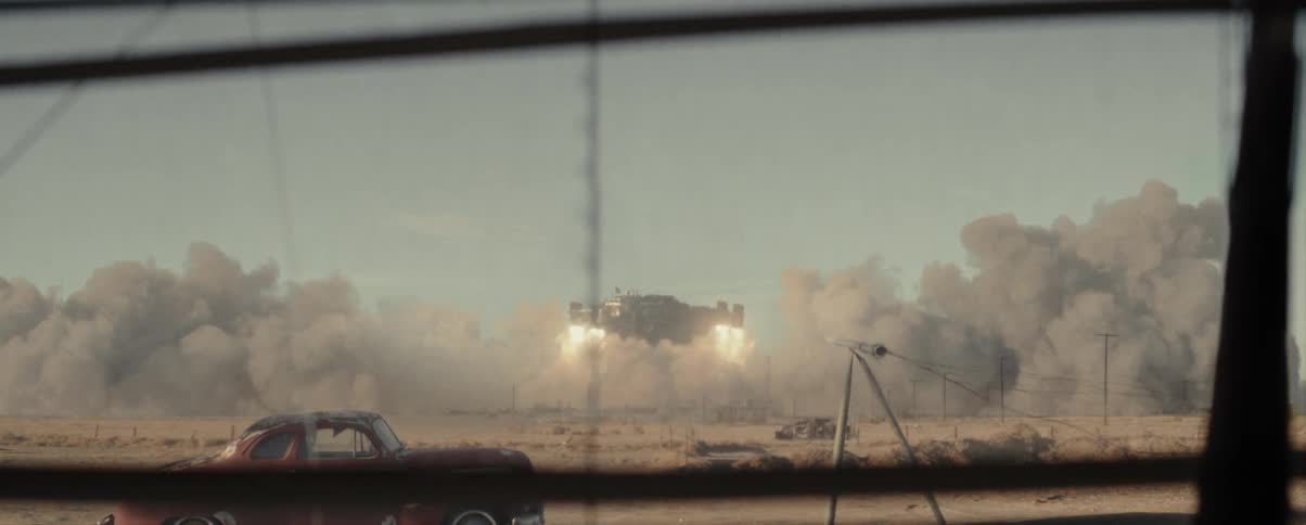 A space ship lifts off from the ground kicking up a huge dirt cloud