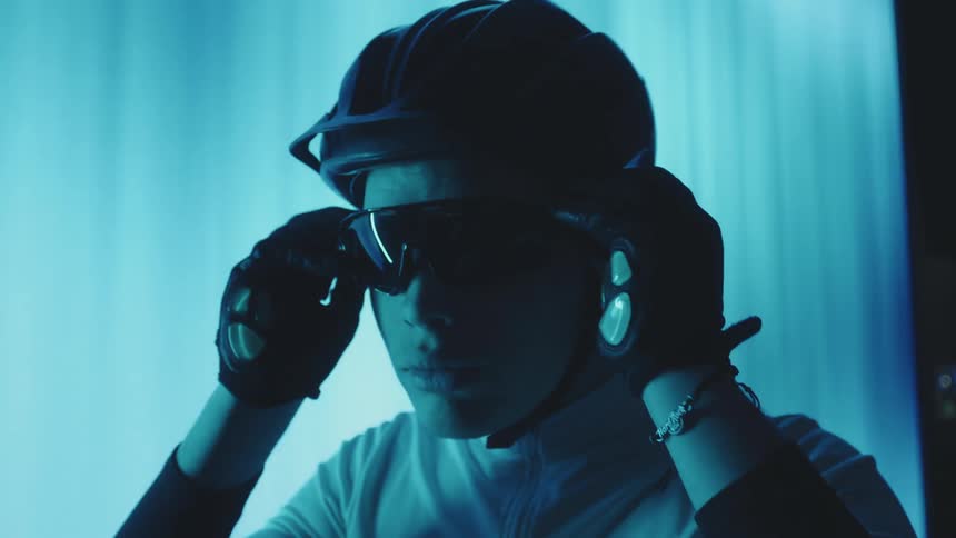 A man puts on a pair of protective glasses and adjusts his helmet