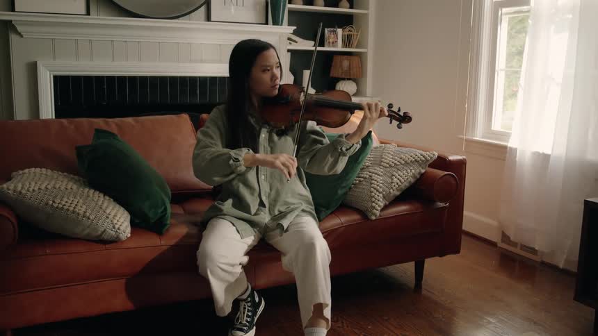 Woman sitting concentrated playing the violin