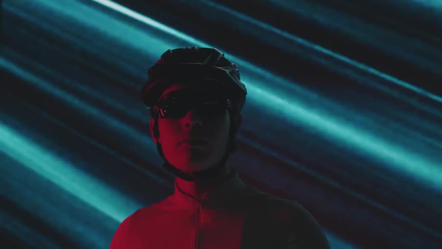 Portrait of a man cyclist with glasses and helmet against a blue screen background with lights