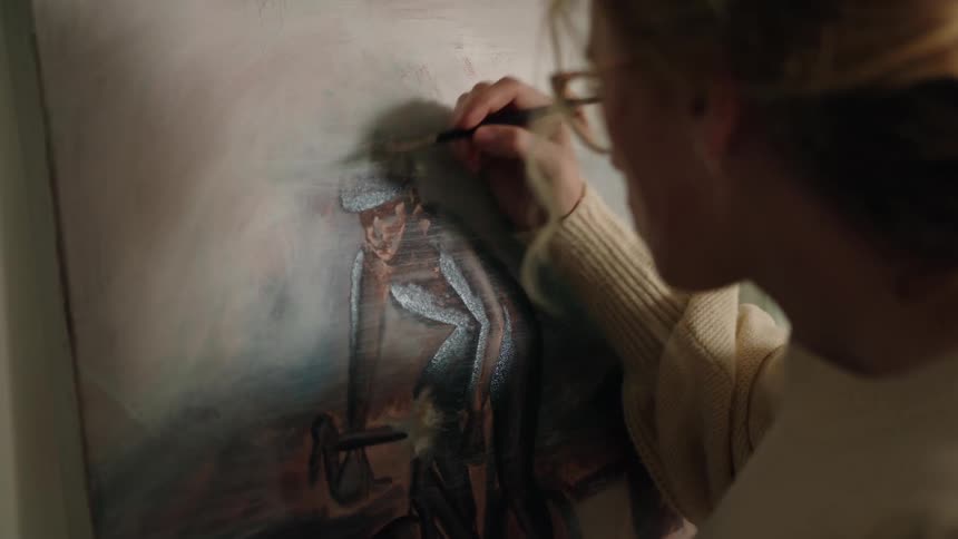 A woman with glasses paints a picture of a person riding a bike