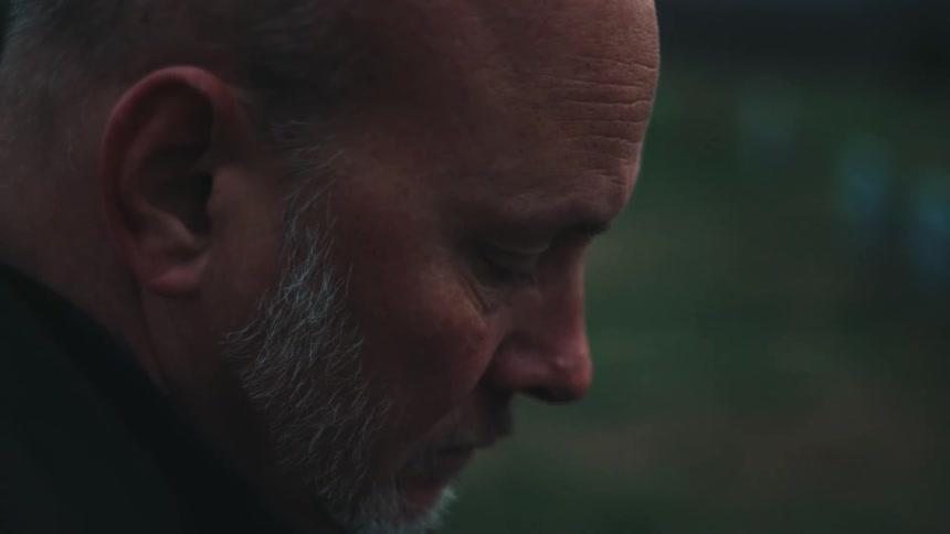A side profile of a persons head with a blurred outdoor background