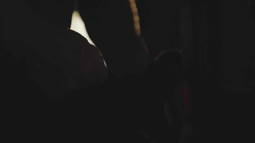Concentrated man putting on boxing gloves