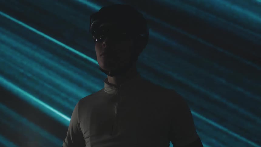 A silhouette of a person against a backdrop of moving diagonal blue light stripes