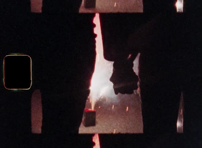 Romantic Super 8 Closeup of the silhouette of a man and a woman holding hands together for the first time while enjoying a fireworks display at night as their love and romance begins
