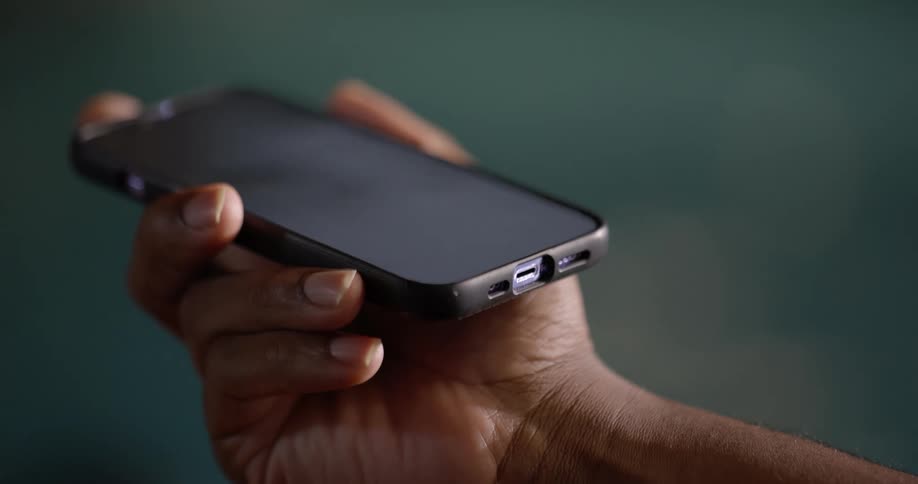 Person holding a smartphone by the side of a pool