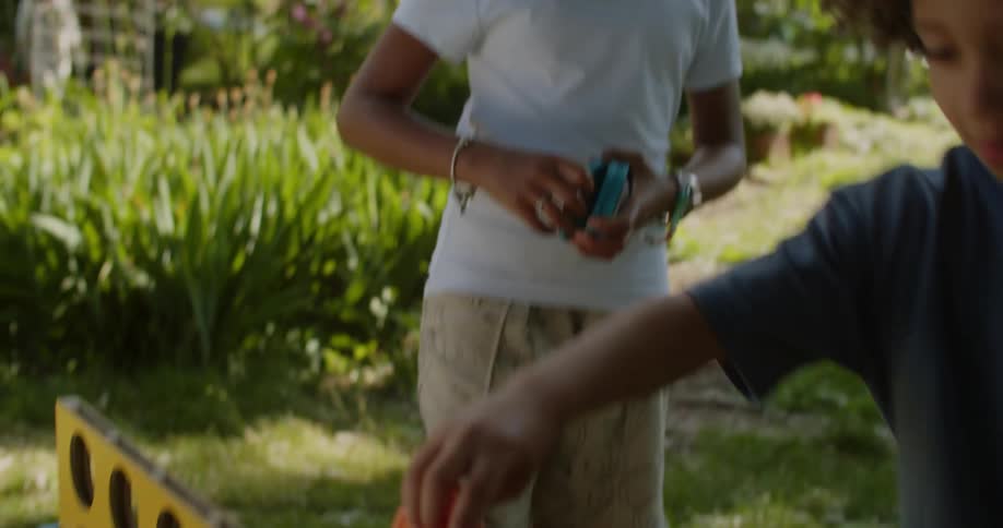 Three children playing a game in a garden