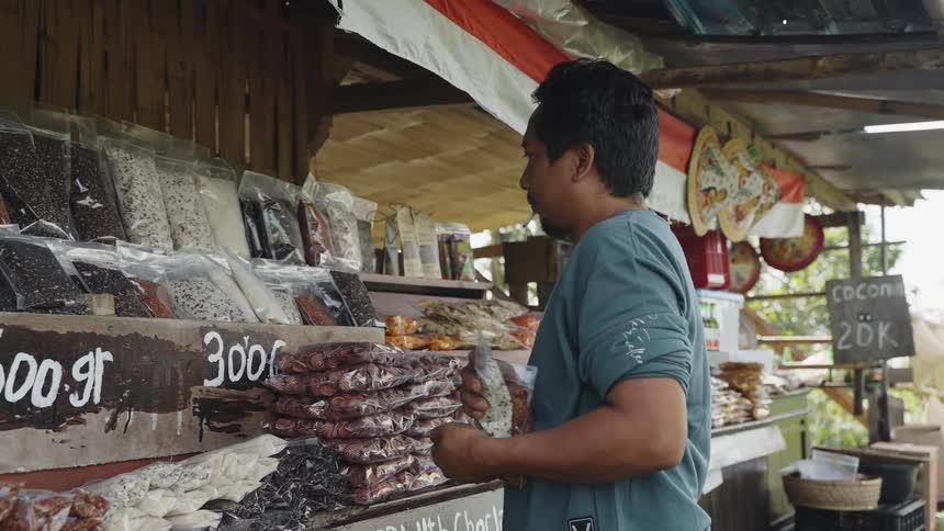 A man stocks the shelves of his roadside market