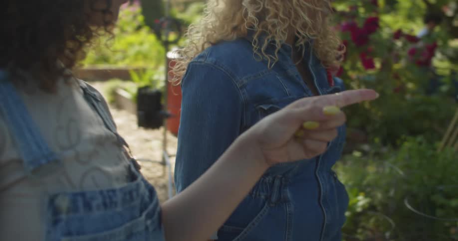 Two women standing in a garden talking