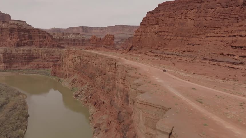 Aerial scene of a canyon on the edge of a cliff with a flowing river