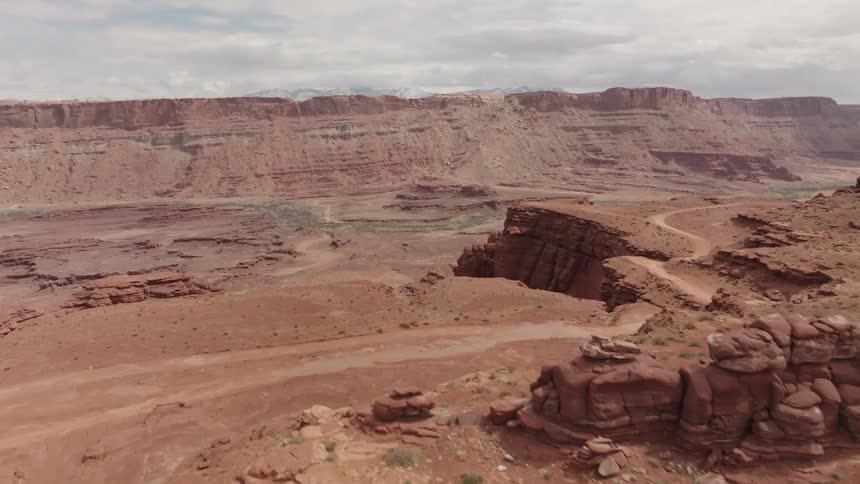 A small sandy road and on top of a canyon in a rocky desert