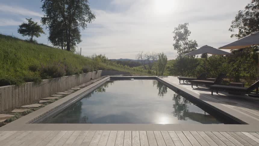 Swimming pool with umbrellas around it on a wooden deck
