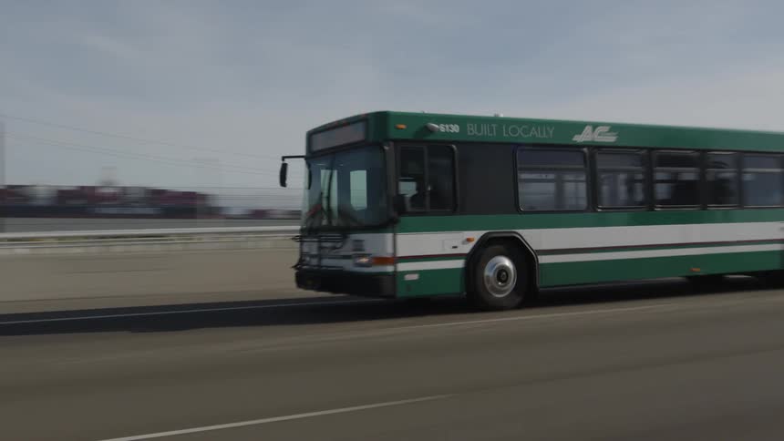 Green bus traveling along a road