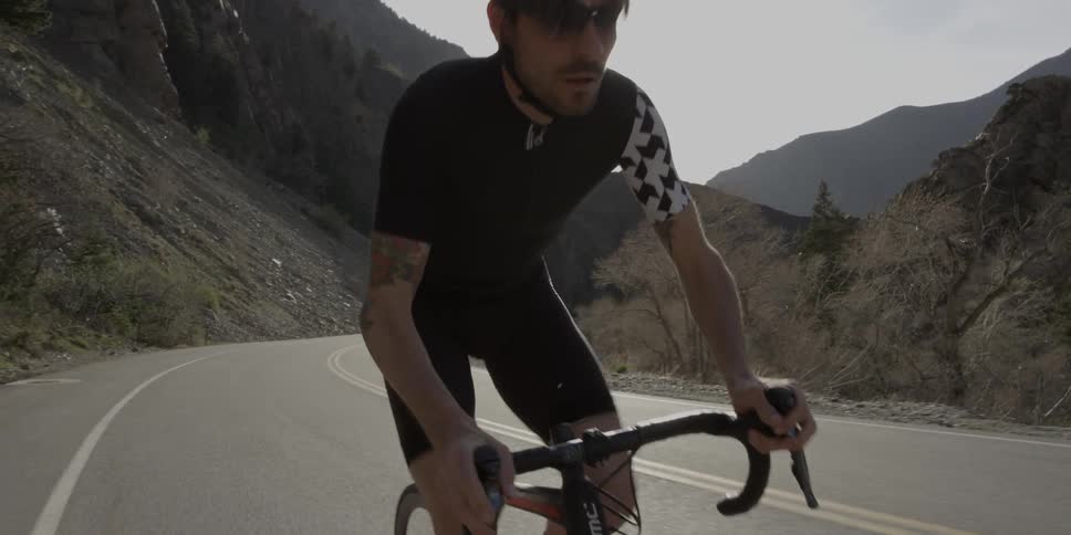 A man is riding his mountain bike uphill on a road