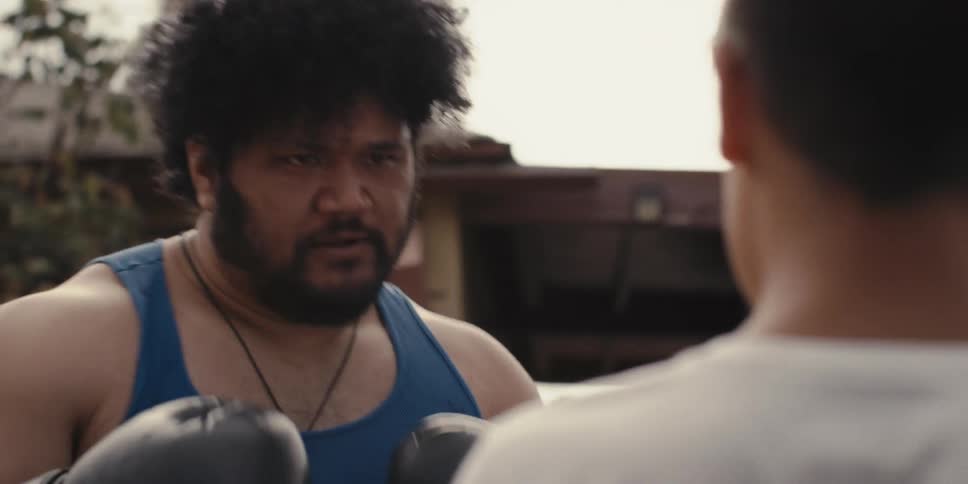Man with a serious expression boxing with a boy