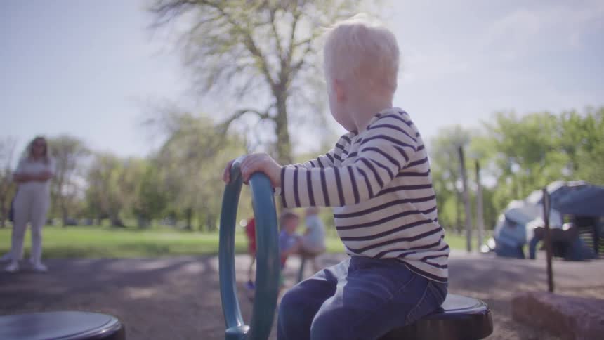 Little boy playing on a toy in a park