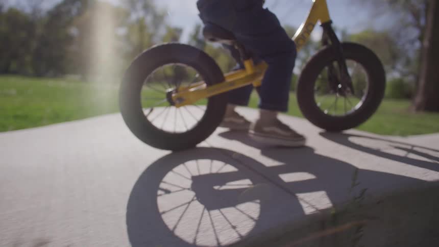 A child rides his bike on the hills of the path