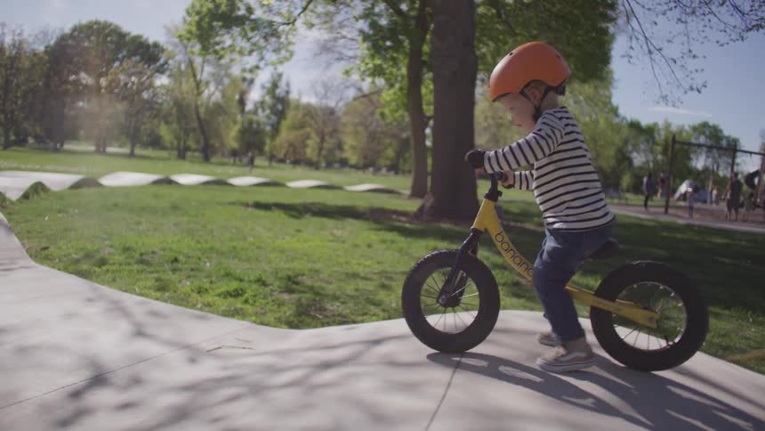 A child is riding his bicycle in the park