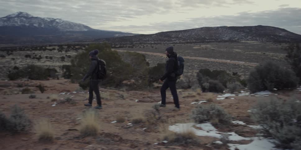 Backpacking couple walking through a barren wilderness