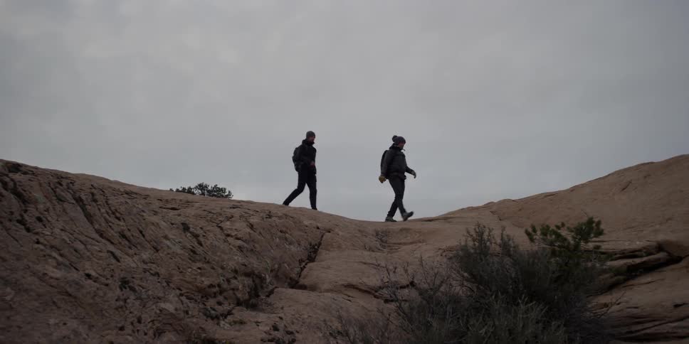 Hiking couple traversing a barren land on a cloudy day