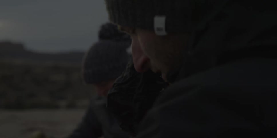Two people sit down at camp at dawn