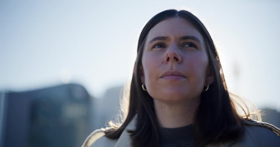 Woman standing outdoors in the city looks around