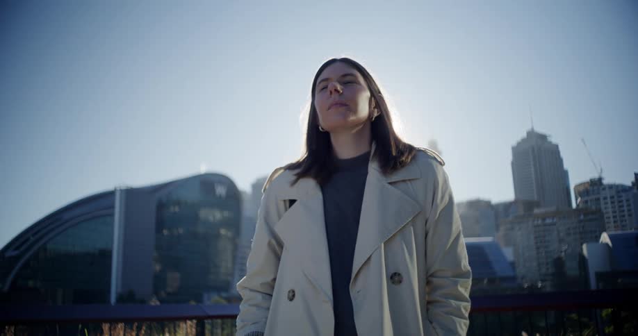 Sun glare temporarily partially obscures woman walking through the city