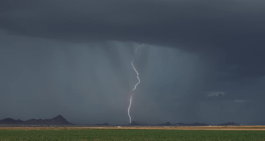 A stormy landscape with multiple lightning bolts striking the ground