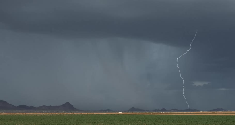 Storms with thunder and black clouds above a field