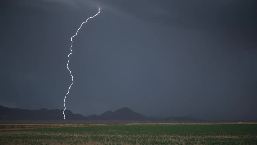 A storm of bright rays falling to the ground in a field of grass