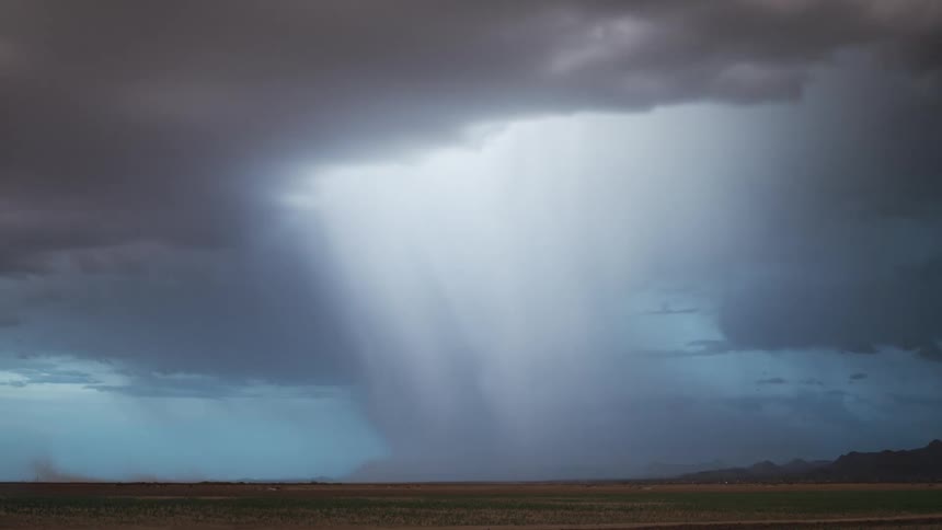 Storm with rain and thunder above a field