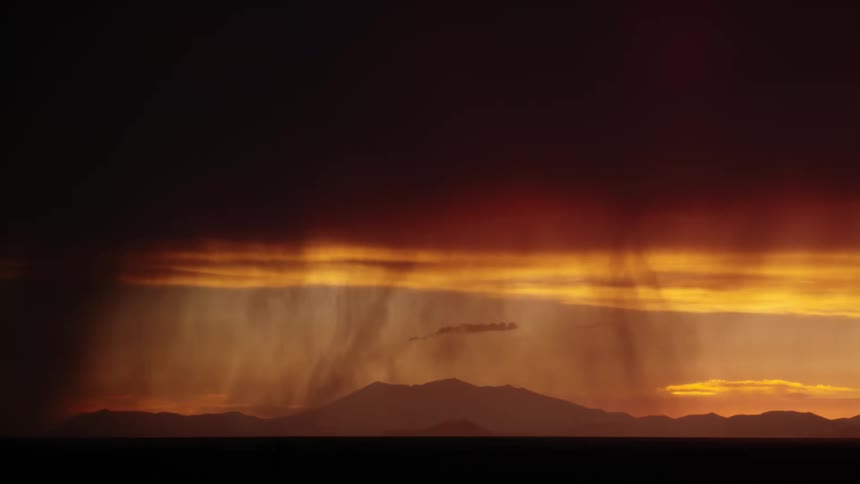 A dramatic landscape with lightning strikes in the distance against dark clouds and an orange sky
