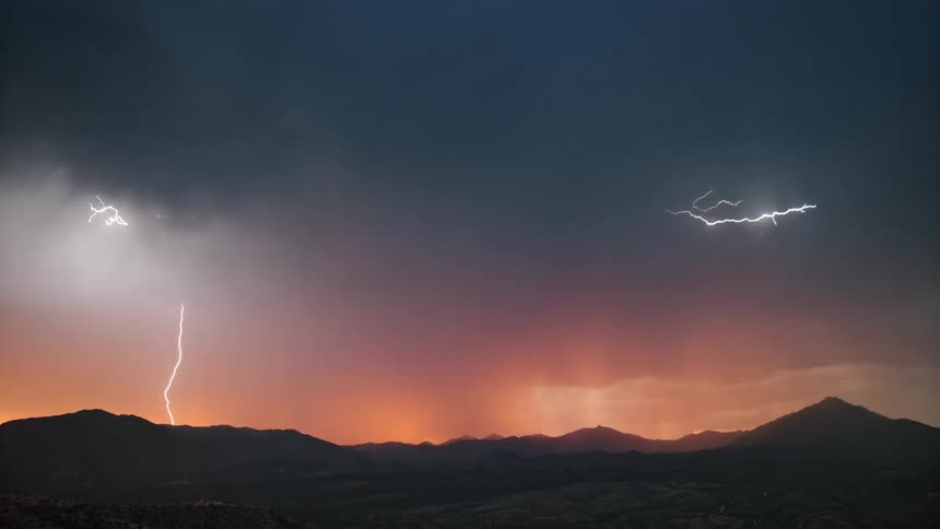 A mountain range landscape with dark clouds multiple lightning strikes above mountainous terrain