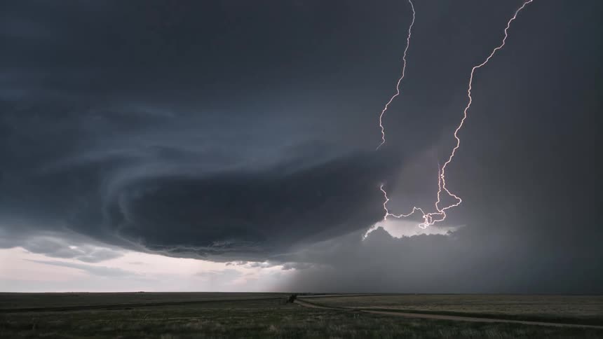 Scenery of a natural field and a sky with storms and lightning that shine