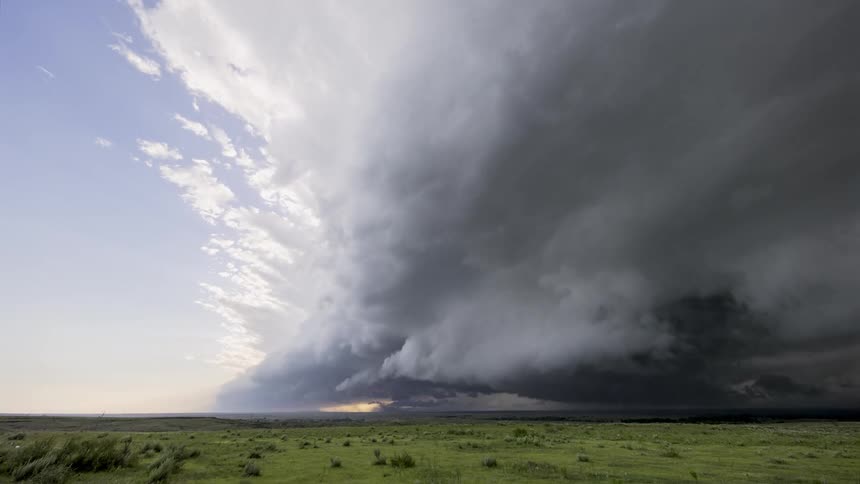 Storm clouds darkening a greenish field