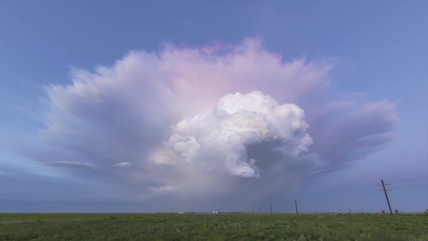 Storm dissipating above a greenish field