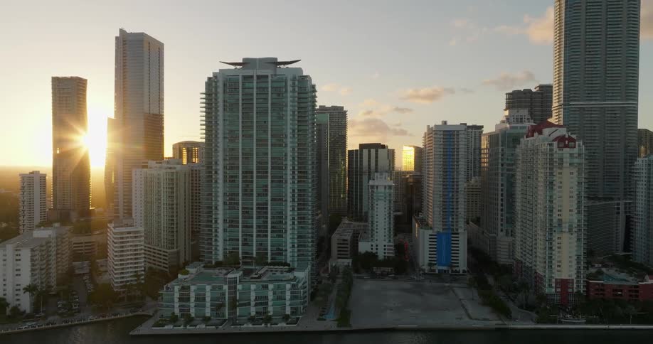 Aerial view reveals a coastal cityscape with highrise buildings at sunset