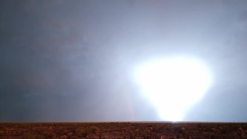 Lightning strikes near a mountain and near a rainbow