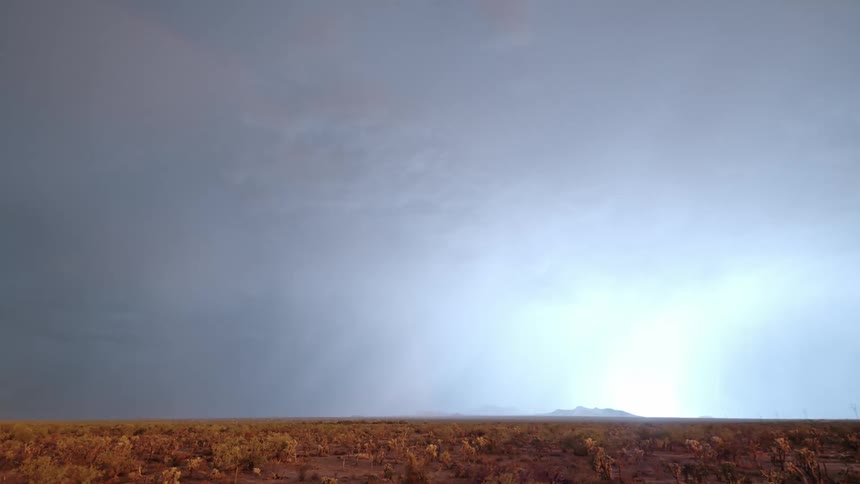 Extensive field against a stormy sky and lightning