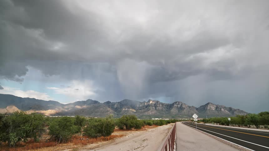 Storm vouchers glowing above mountains and a highway alongside
