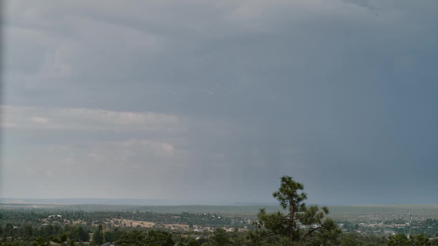 A dramatic thunderstorm with lightning strikes the plains in daylight