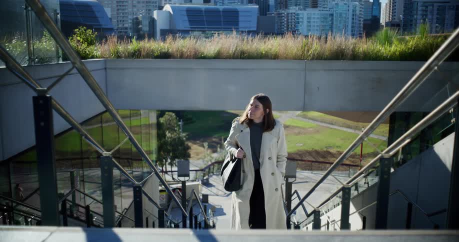 A woman climbs up the stairs in the city