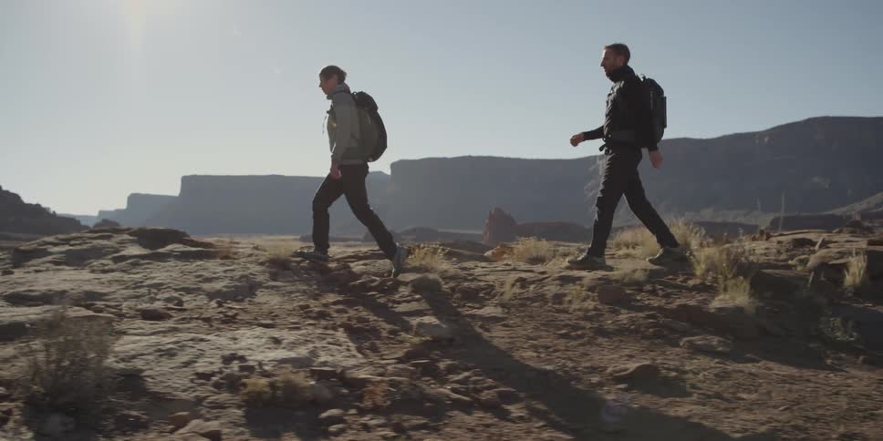 Two men with backpacks hiking in the wilderness