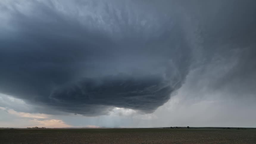 Lightning flashes from a large dark cloud as the sun sets