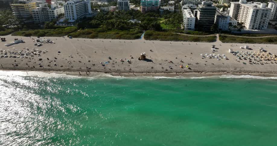 Aerial panorama of a turquoise sea and the coastline full of buildings in a metropolis